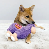 Perro jugando con juguete KONG Sherps Llama de felpa morada