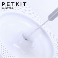 Primer plano de cepillo Petkit limpiando el orificio central de una fuente Eversweet